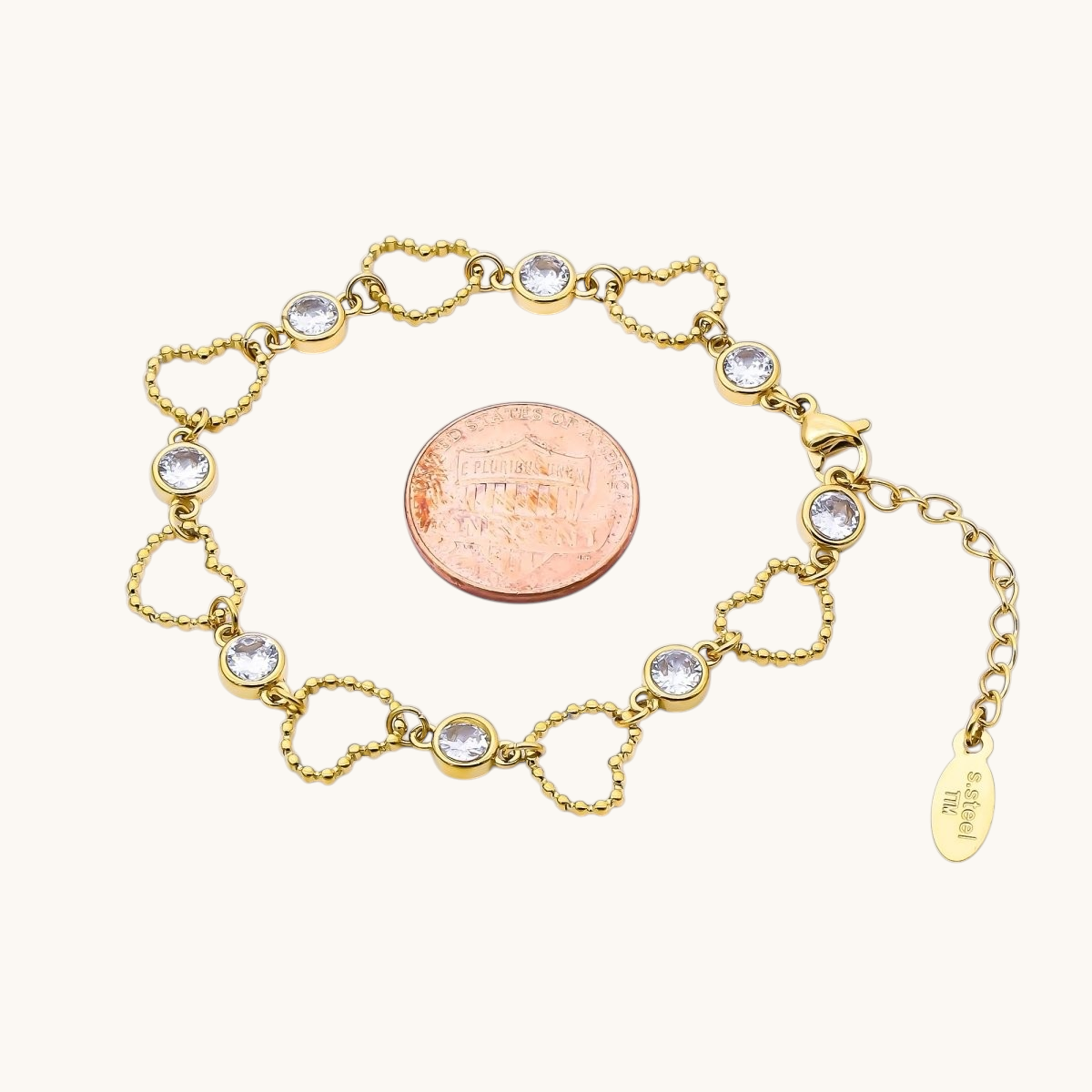 Tessa Vera 18K gold PVD stainless steel bracelet featuring open beaded heart links and clear cubic zirconia stones.